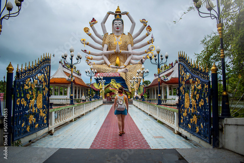 Mujer entrando a templo Wat Plai Laem, en isla Koh Samui, Tailandia