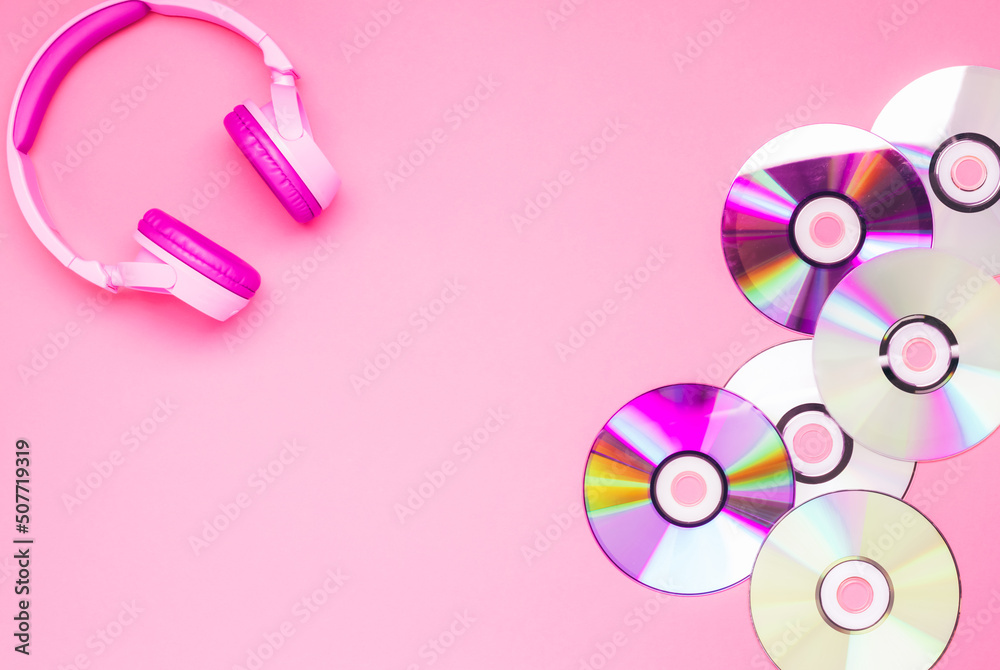 Pink youth headphones music cd discs on a pink background, flat lay copy space. Hobby entertainment technology Pink youth headphones music cd discs on a pink background, flat lay copy space. Hobby entertainment technology