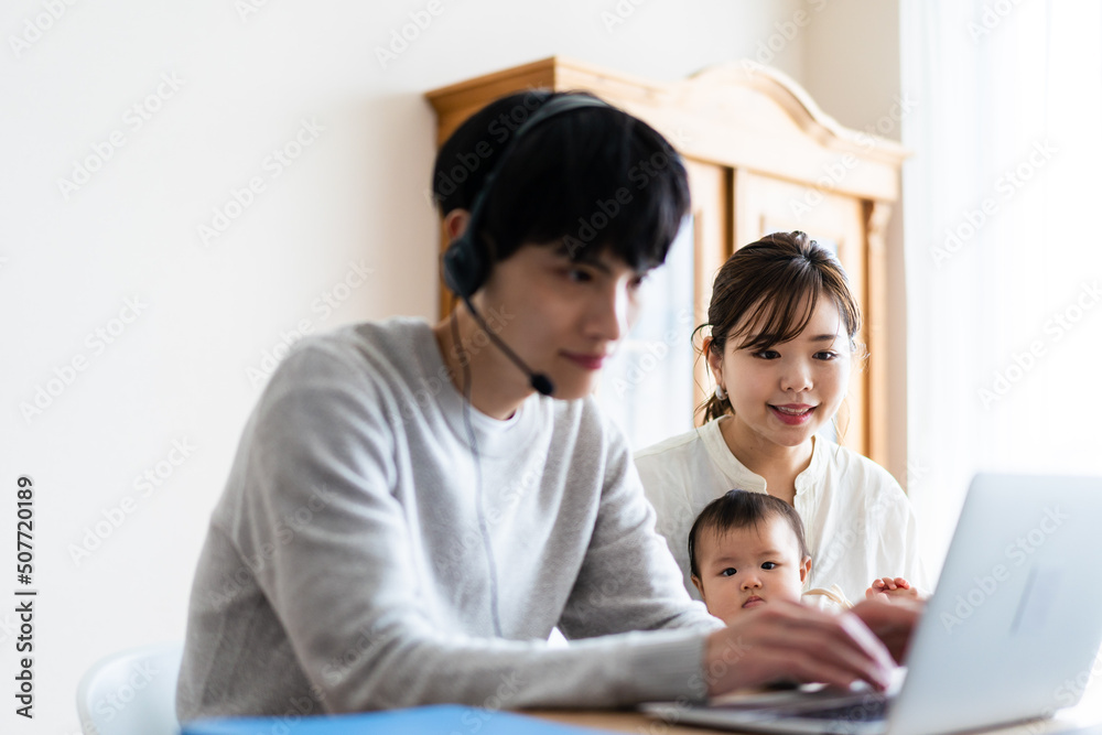 在宅勤務をするお父さんと子育てをするお母さん 在宅勤務をするお父さんと子育てをするお母さん