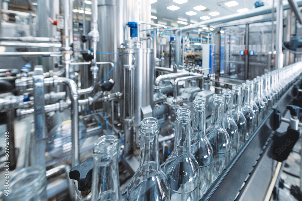 Obraz premium Production line transports empty glass bottles for alcohol