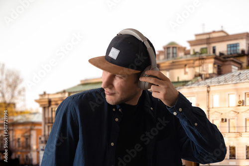 young man listen to music and walk in the street outdoors, summer relax