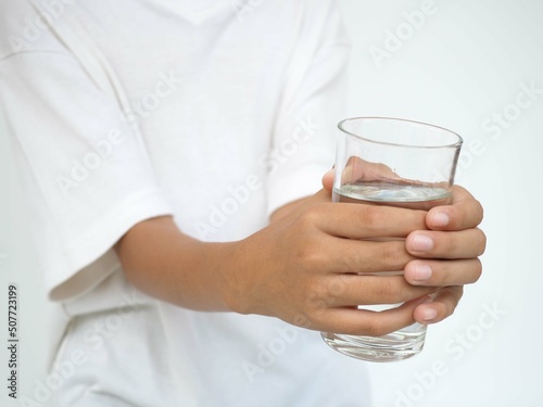 Boy with a glass of water on white background.