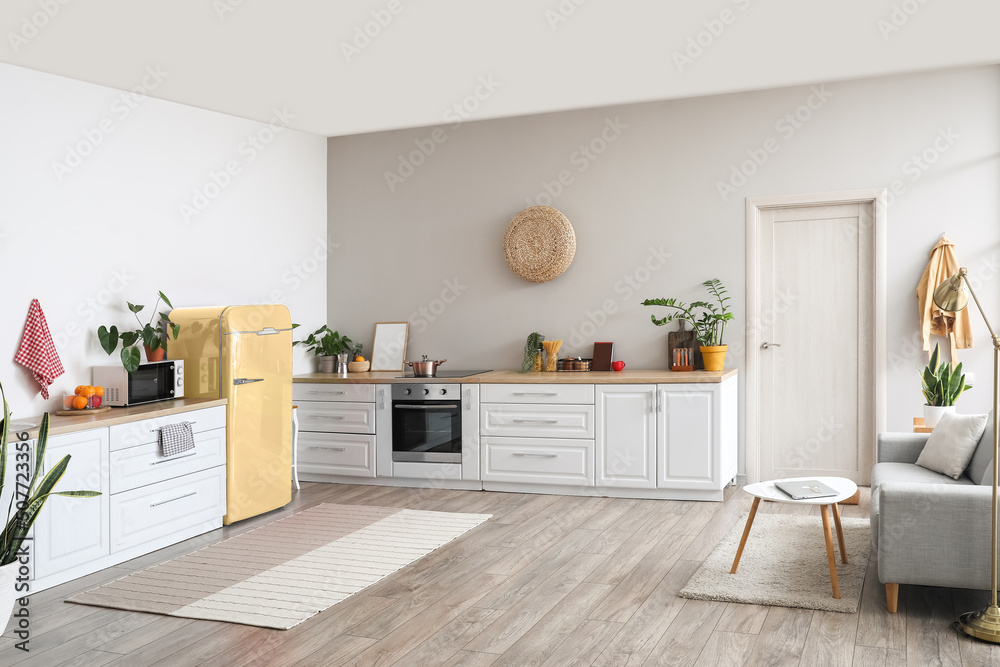 Interior of modern kitchen with stylish yellow refrigerator