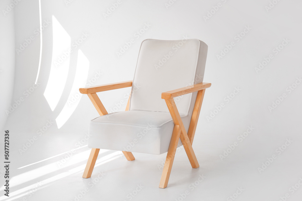 Fototapeta premium Stylish wooden armchair in modern photo studio