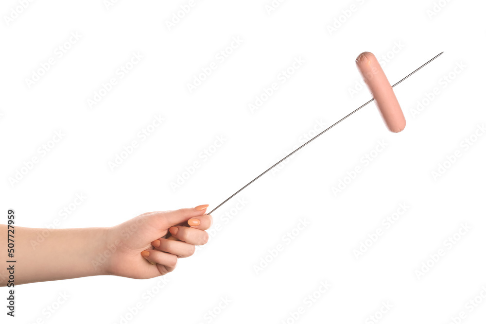 Female hand holding wooden skewer with sausage on white background Female hand holding wooden skewer with sausage on white background