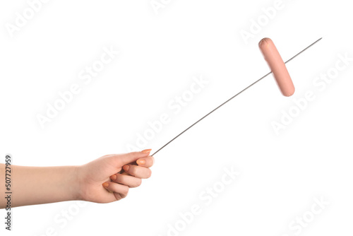 Female hand holding wooden skewer with sausage on white background