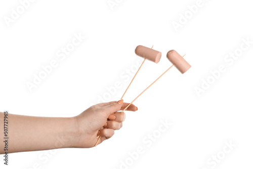 Female hand holding wooden skewers with sausage on white background