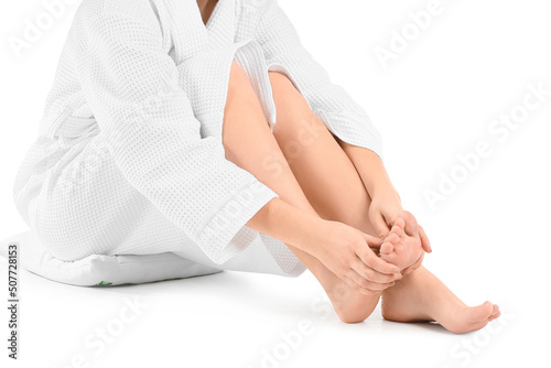 Young woman making foot massage on white background, closeup