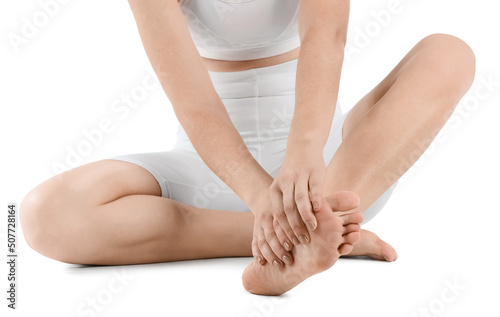 Young woman making foot massage on white background, closeup
