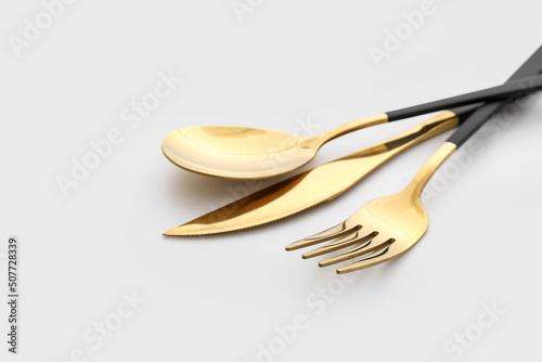 Set of stainless steel cutlery with black handle on white background, closeup