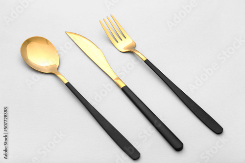 Set of stainless steel cutlery with black handle on white background