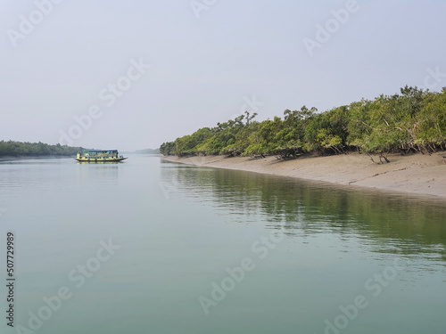 Sundarban, West Bengal, India - December 27, 2021: boat crossing the river at sundarbans national park photo