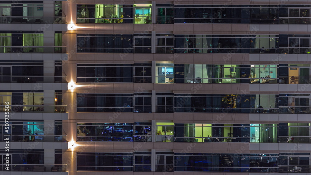 Flat night panorama of multicolor light in windows of multistory buildings aerial timelapse.