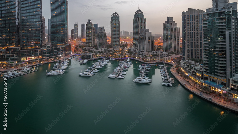 Obraz premium Luxury yacht bay in the city aerial night to day timelapse in Dubai marina
