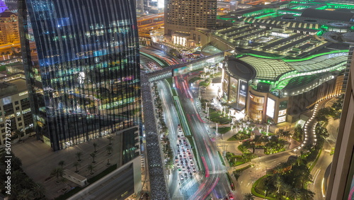 Aerial panorama of Downtown Dubai with shopping mall and traffic on a street night timelapse from above, UAE