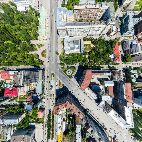 Aerial city view with crossroads, roads, houses, buildings, parks and parking lots. Copter drone helicopter shot. Panoramic wide angle image.