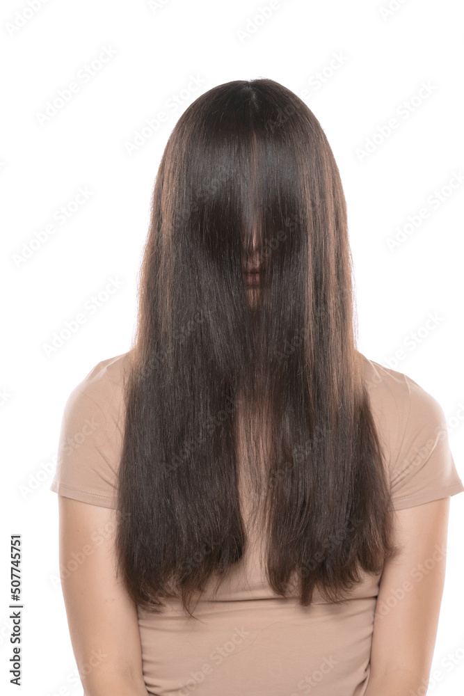 A woman with the hair over her face on a white studio background A woman with the hair over her face on a white studio background
