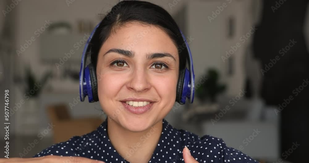 Close up Indian vlogger sit indoor wear headphones talk to camera, record new videovlog for internet subscriber, student talk to schoolmate use videocall app. Share knowledge, video call event concept