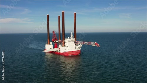 Special wind turbine servicing vessel with jack up legs off coast of larne - drone view photo