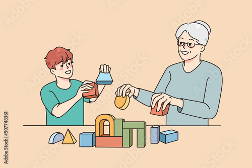 Loving elderly grey-haired grandmother play toys with small grandchild. Caring grandma build with blocks with smiling little boy child at home. Two generations. Vector illustration. 