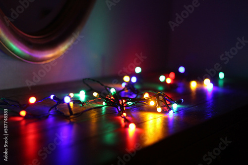 Christmas lights on wood table. Mirror. Beautiful Overlay bokeh light texture. Night time