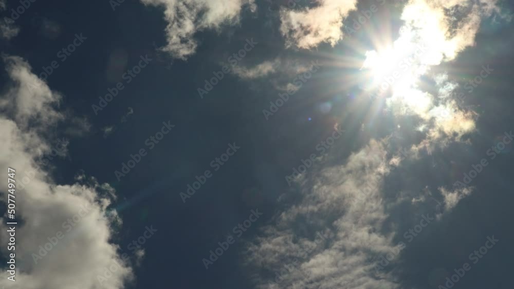 Sun flare hiding and opening behind the clouds timelapse Sun flare hiding and opening behind the clouds timelapse