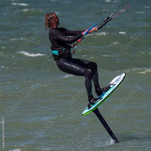 Male Kite Foil Surfer with beard and long hair on the sea. Close up photo