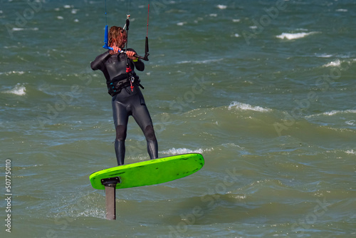 Male Kite Foil Surfer with beard and long hair on the sea. Close up photo