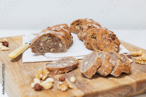 Dish towel and fresh homemade pain paillasse bread on wooden cutting board photo