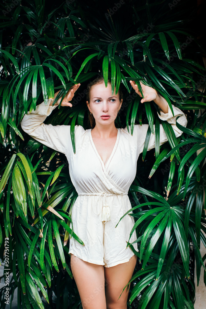 Portrait of young beautiful woman posing amid tropical plants Portrait of young beautiful woman posing amid tropical plants