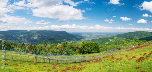 Fototapeta Naklejka Na Ścianę i Meble -  Panoramic view from the top of the heat towards the north. The summer toboggan run . Lake Czanieckie and the Międzybrodzkie in the background. View of the Silesian Beskids and the Little Beskids.