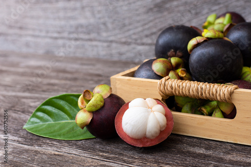 Fresh mangosteen fruit in box on rustic wooden table background. photo