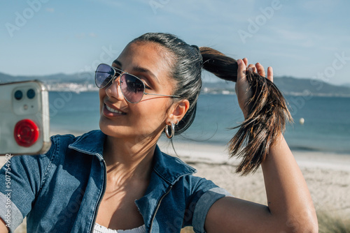 happy young woman taking a selfie on the coast