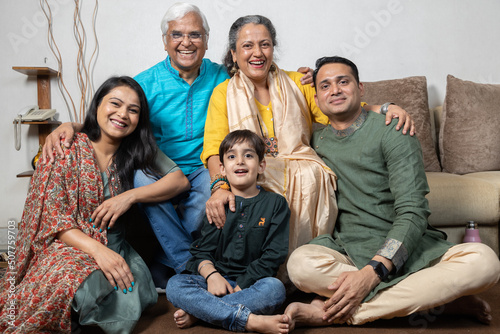 portrait of happy indian family sitting at sofa	 photo