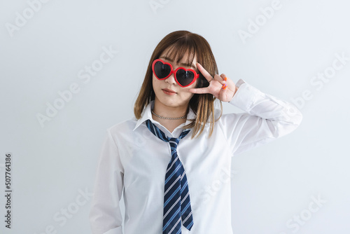 ハートのサングラスをした女子高生 © peach100