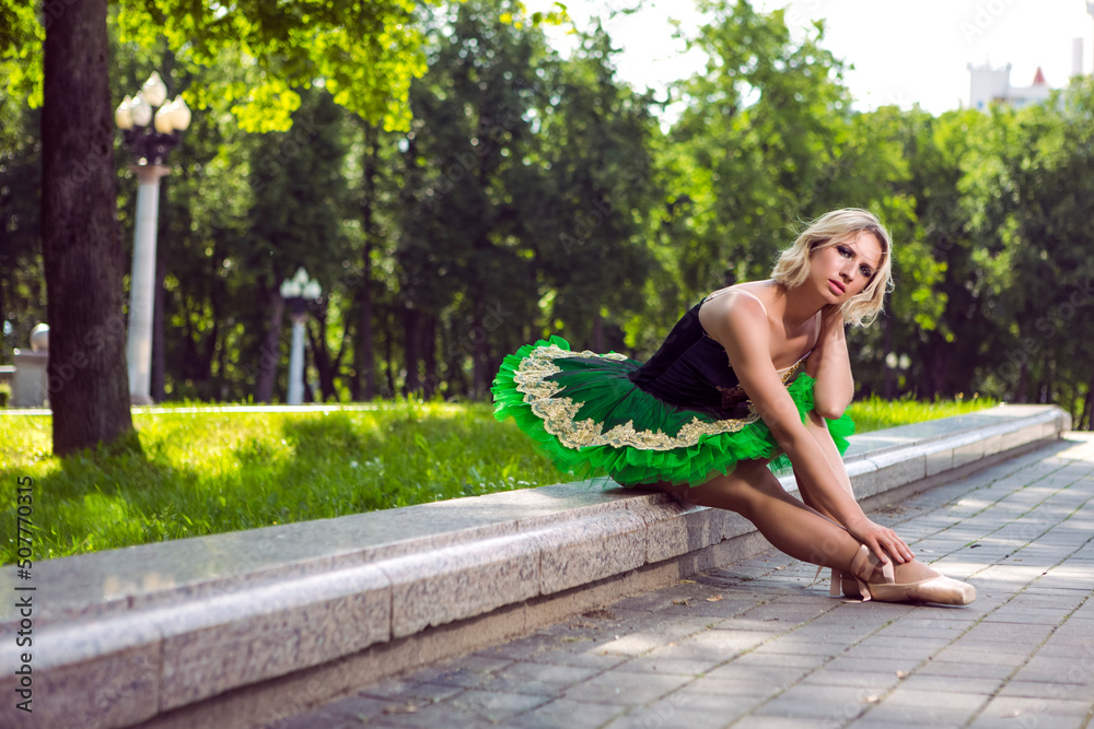 Ballet and Dance Concepts. Professional Caucasian Ballet Dancer in Green Tutu Dress Posing in Dance on City Street Outdoor.