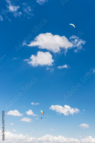 Fototapeta Naklejka Na Ścianę i Meble -  Two paragliders against a beautiful blue sky. Top view of the embers in the Beskid Mały. A popular place in Silesia. Międzybrodzie bialskie, Poland