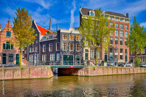 Travel Destinations. Romantic Amsterdam River Canal For Transportation and Boat Cruises For Guests and Visitors Along Arched Bridges in Amsterdam photo