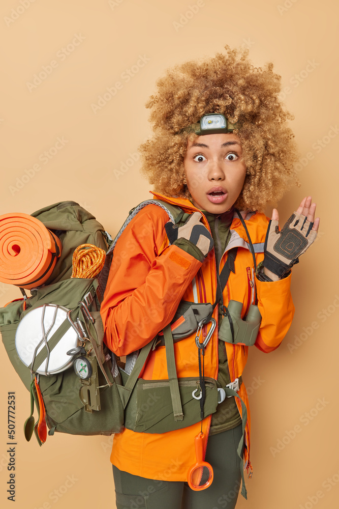 Embarrassed Shocked Curly Woman Dressed In Active Wear Wears Headlamp Prepares For Exploration