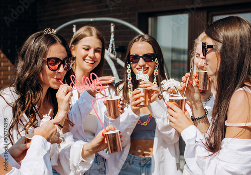 Happy and cheerful group of women friends together dancing and drink champagne on the rooftop at home. Bachelorette party.