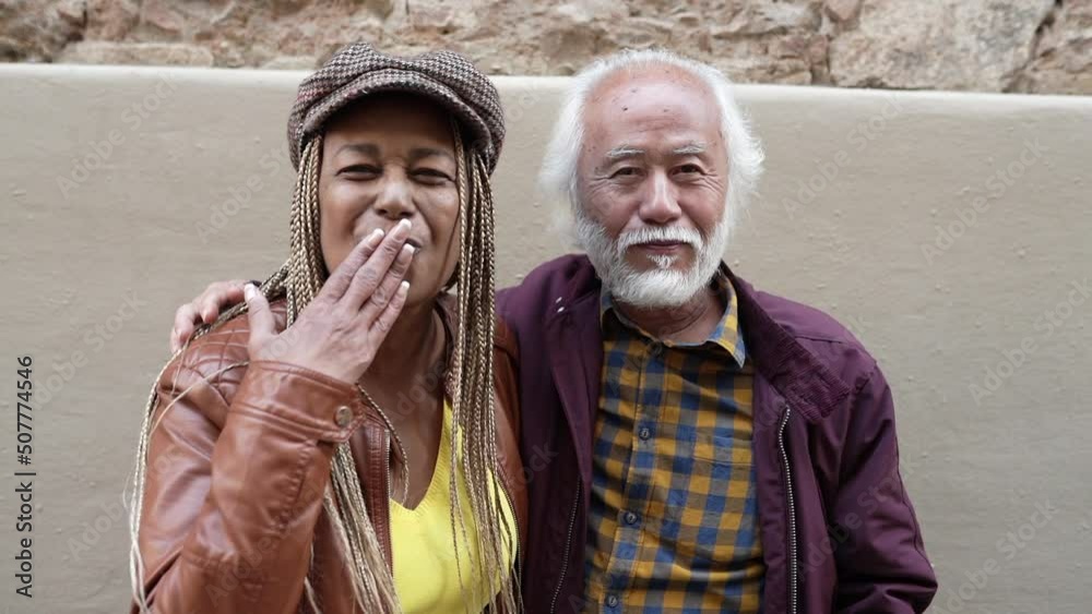 old man and woman, multiracial couple, asian and african, greeting and giving kisses to camera video call