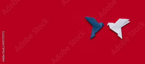 banner two blue and white doves made of origami paper on red background