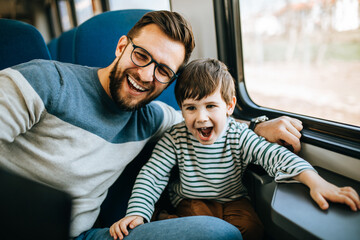 Father and son travel together by fast train and taking selfie photo.