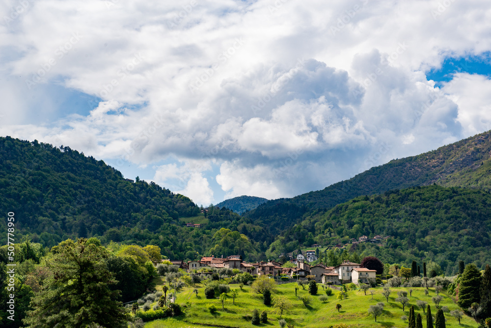 Village among green hills on the slopes of the Italian Alps not far from Lake Como, photo taken in spring. Picturesque landscape