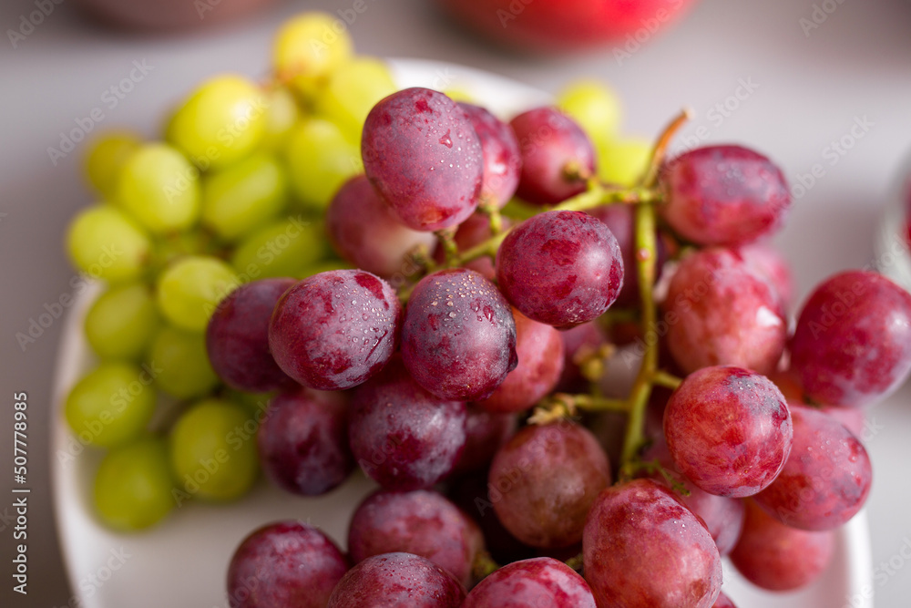 Fresh red and green grape on plate, close-up. Healthy lifestyle concept. Fresh red and green grape on plate, close-up. Healthy lifestyle concept.