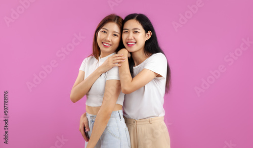 Happy Young asian women in white t-shirt posing smiling in a concept of lgbt couple and lesbian on pink color background.