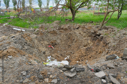 A shelling crater in a garden in a Ukrainian city.