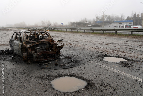 Burnt car during the war in Ukraine. Destroyed buildings, roads. Technique of civilian Ukraine.