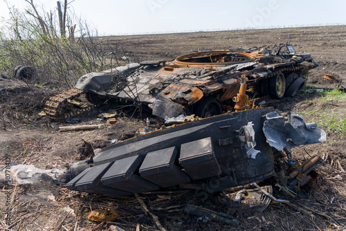 Burnt tank, armored personnel carrier, city of Ukraine. Destroyed cities. Demilitarization of Russia in the war. photo