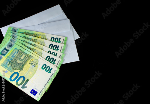 Euro in a white envelope on a black background. The concept of the 